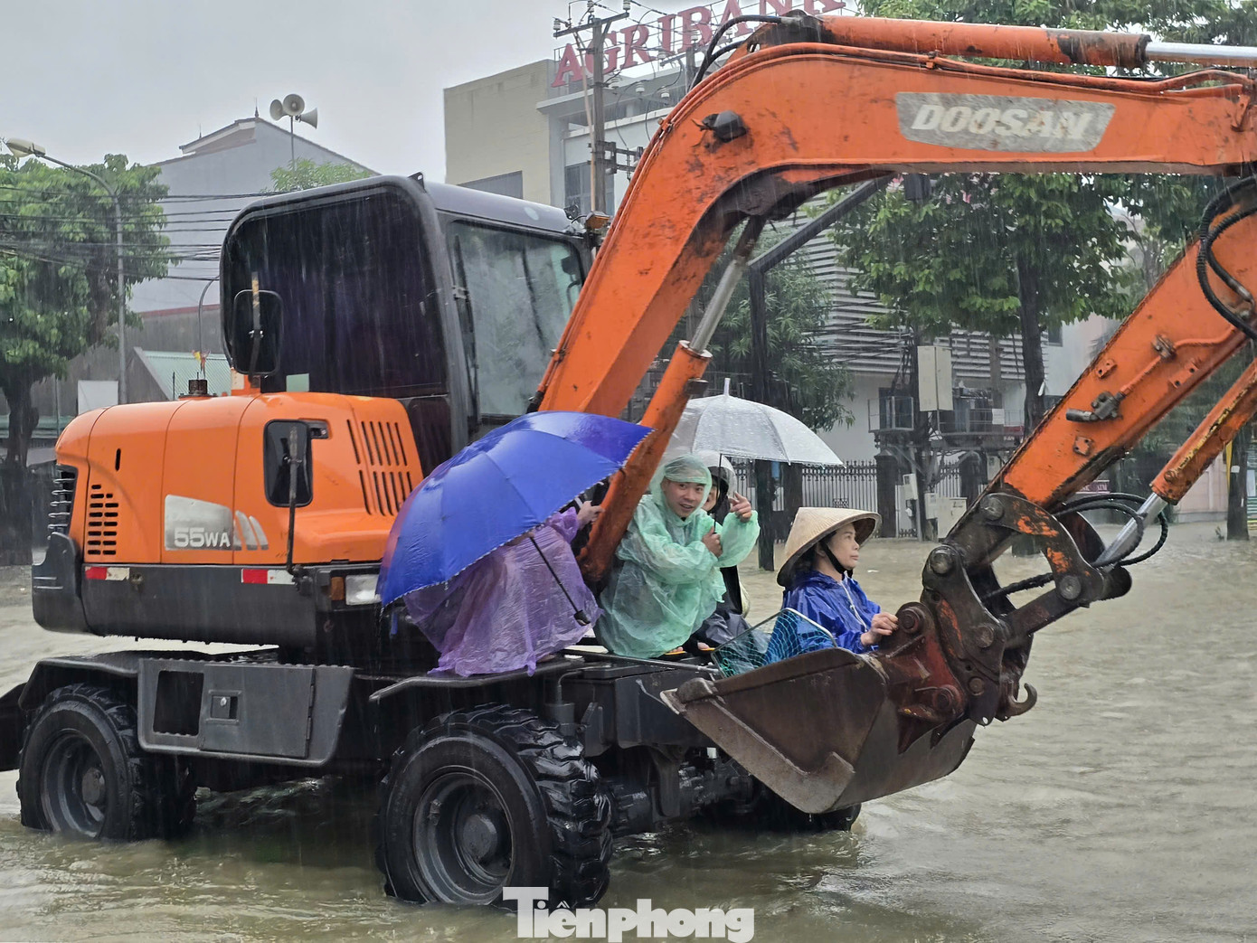 Một số được "cứu trợ" bằng cách ngồi lên gàu máy múc để qua đường.