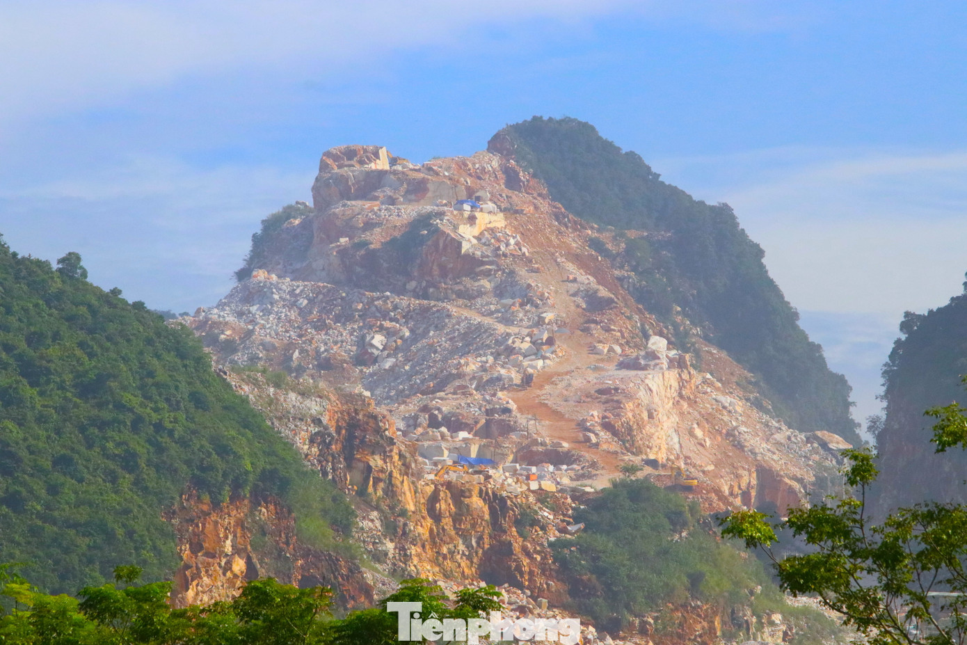 Trên triền dốc núi, những hòn đá sau khai thác để chỏng chơ. Nhiều tảng đá đang được cắt xẻ thành từng khối để đưa đi.