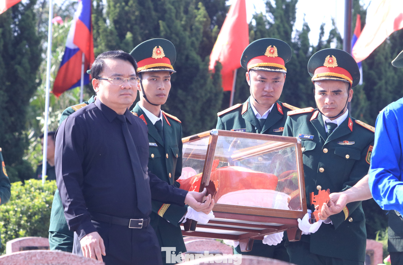 Các đại biểu di chuyển hài cốt liệt sĩ đến vị trí an táng trong nghĩa trang.