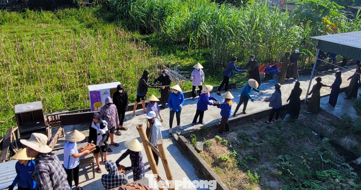 Bất kể ở dưới đất hay trên mái nhà cũng đều có màu áo xanh tình nguyện hỗ trợ.