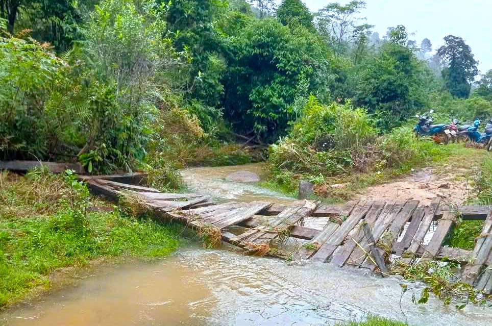 Cây cầu bị sập xuống khe suối sau đợt mưa lũ khiến việc đi lại của người dân gặp nhiều khó khăn.