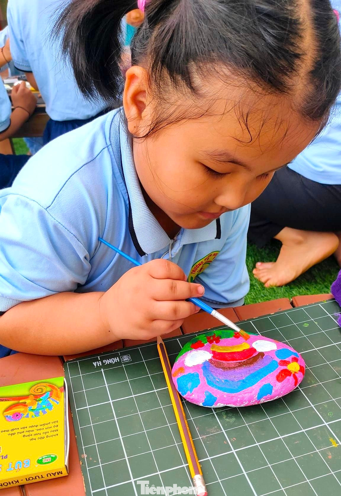 Các em nhỏ thích thú, hào hứng khi được trực tiếp vẽ lên những viên đá tạo tranh.