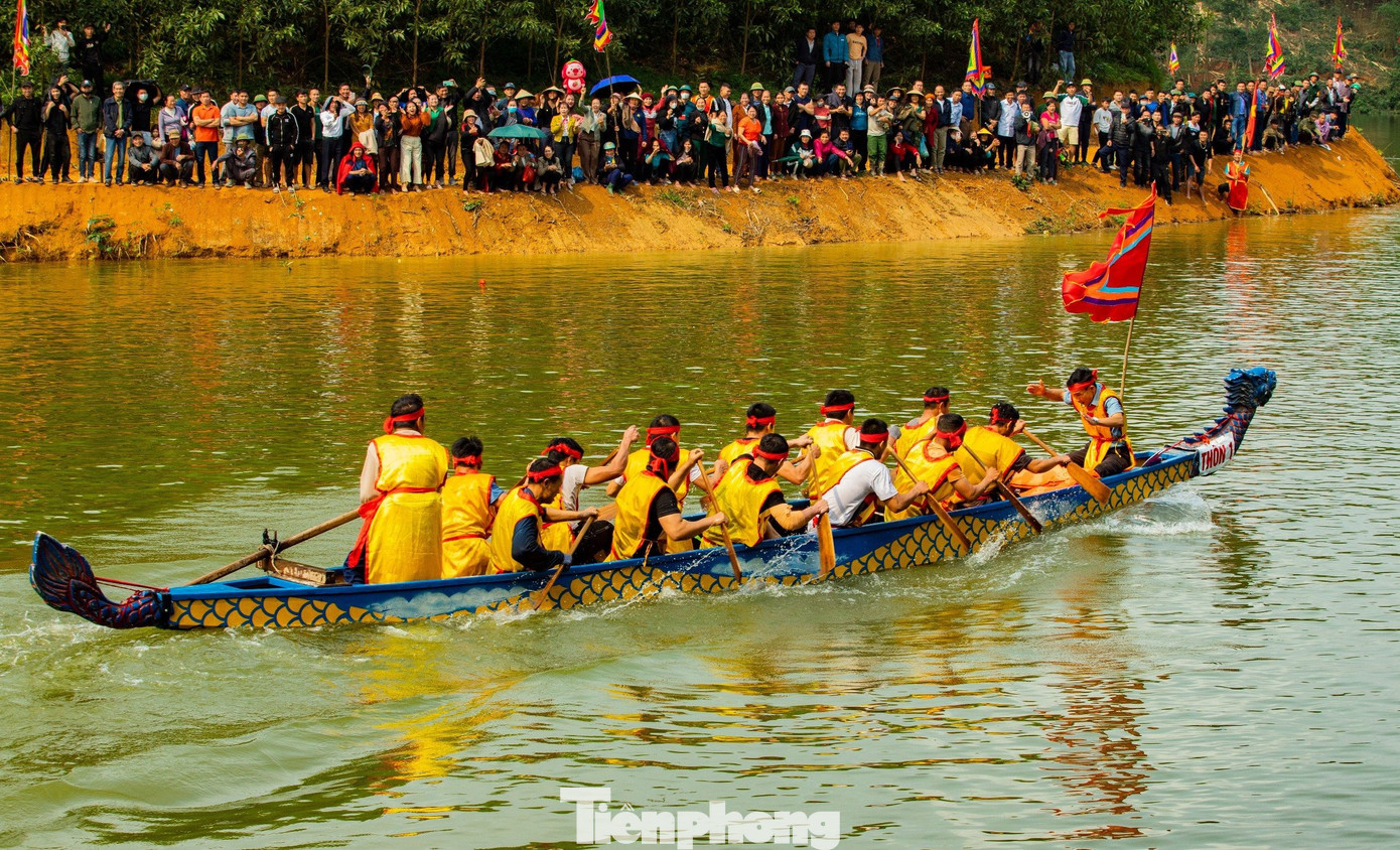 Trên bờ, hàng nghìn người dân đứng hò reo cổ vũ tạo nên sự hưng phấn cho các tay đua dưới nước. (Ảnh: Rạng Đông).