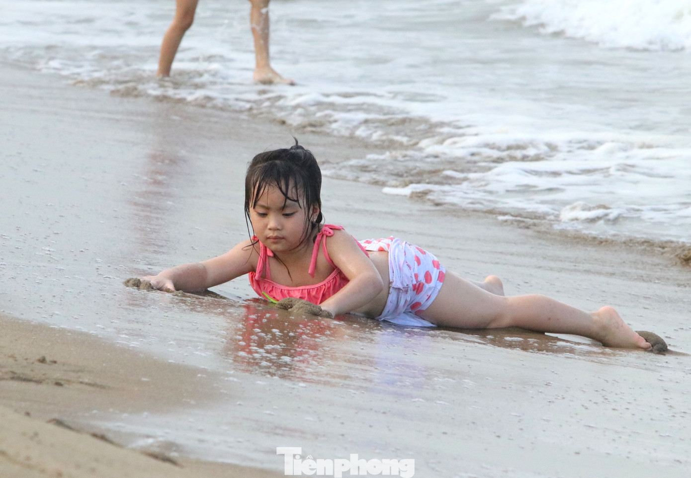 Trong khi đó, nhiều em khác lại nằm ở mép nước chờ sóng biển đánh lên tạo cảm giác thích thú.