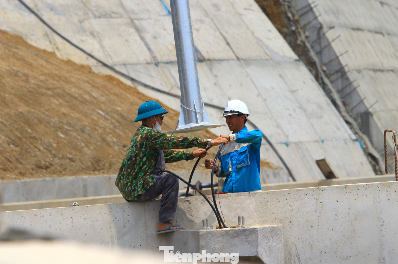 Các công nhân đang khẩn trương lắp đặt hệ thống đèn điện trên đường.