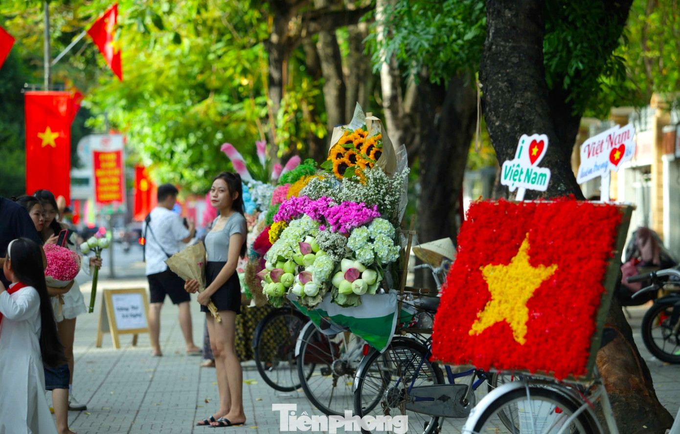 Trên vỉa hè, nhiều người kinh doanh đã bố trí sẵn những chiếc xe đạp chở đầy hoa tươi để du khách có thể đến thuê chụp hình.