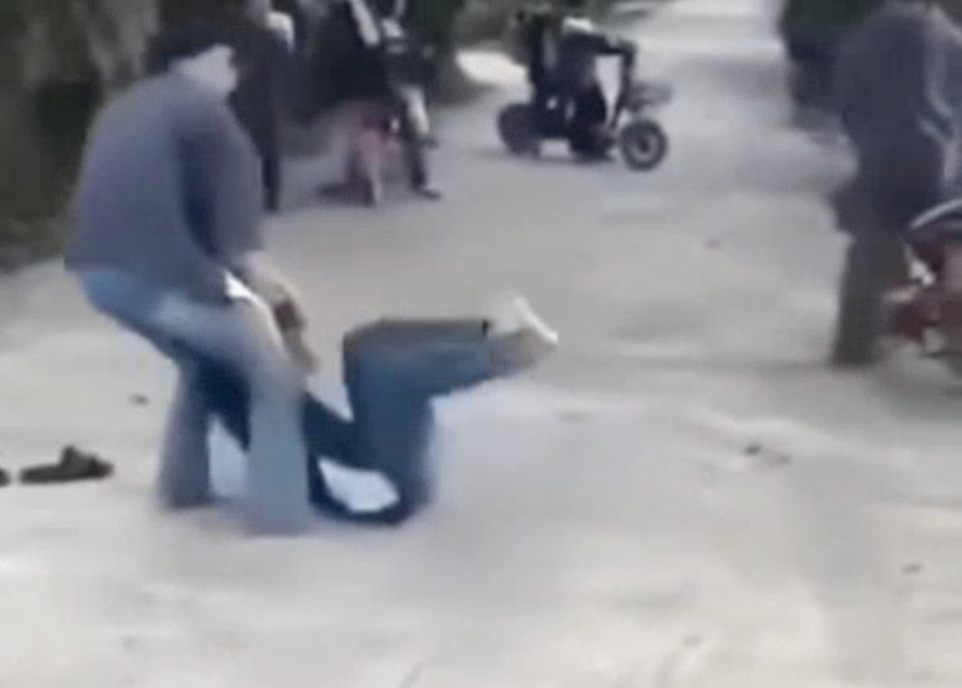 Khi một nữ sinh ngã, người còn lại tiếp tục túm tóc, dùng chân đạp mạnh vào người đối phương.