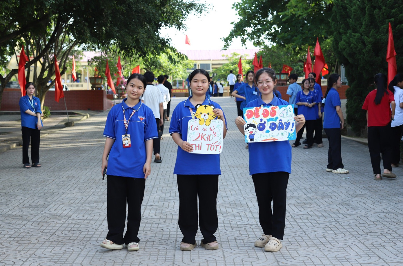Các đoàn viên thanh niên huyện Anh Sơn (Nghệ An) viết những câu chúc động viên sĩ tử tại điểm thi trường THPT Anh Sơn 1. Ảnh: Rạng Đông
