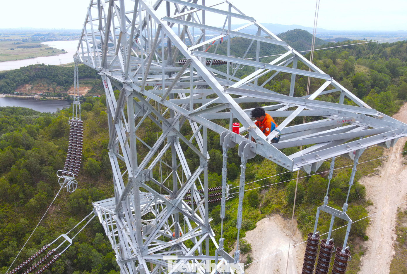 Phía trên cao, các công nhân phải đu mình làm việc. Bất chấp nắng nóng, gió Lào thổi bỏng rát, các công nhân vẫn bám trụ trên cao để lắp đặt đường điện. Phía trên cao, các công nhân phải đu mình làm việc. Bất chấp nắng nóng, gió Lào thổi bỏng rát, các công nhân vẫn bám trụ trên cao để lắp đặt đường điện.