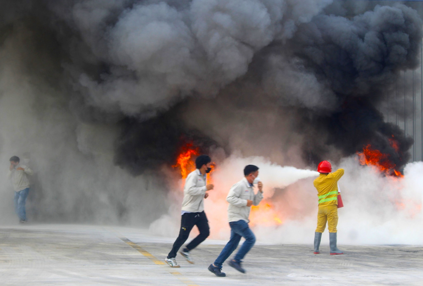 Cảnh sát dùng bình xịt để dập tắt đám cháy phía ngoài công ty.