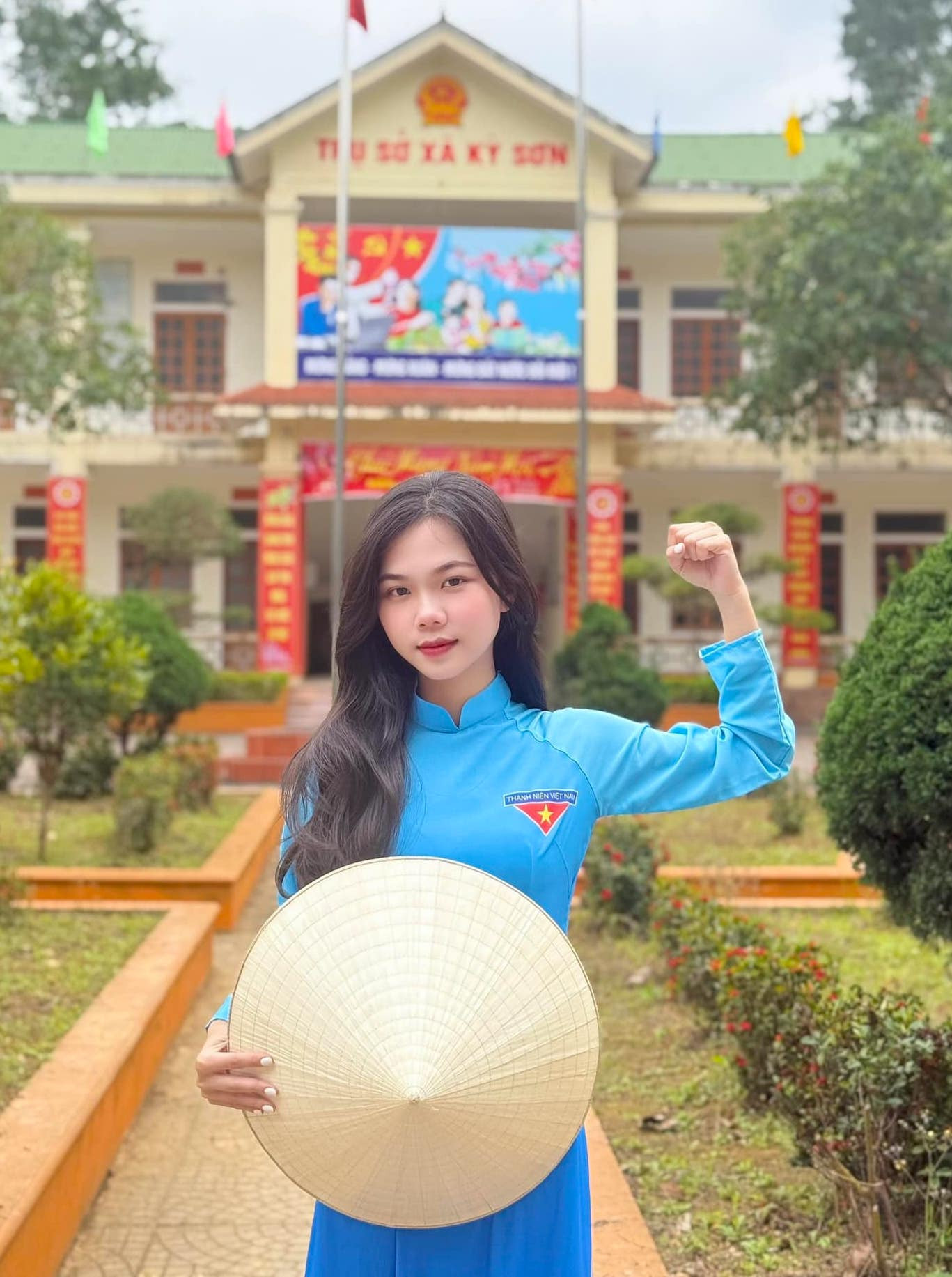 Nữ đoàn viên thanh niên biểu thị quyết tâm cùng tà áo dài thanh niên và nón lá.