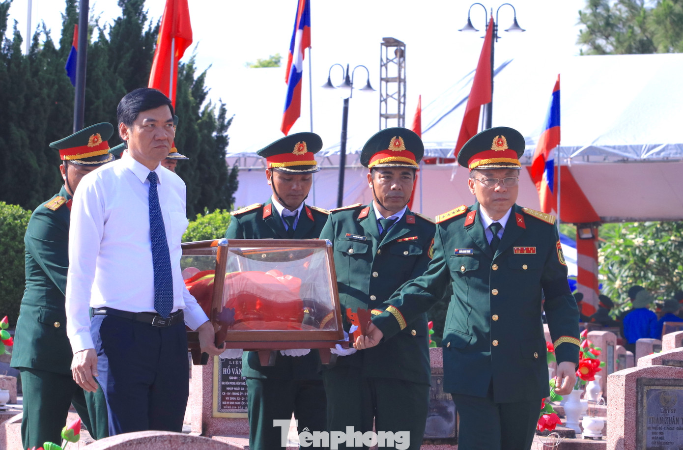 Các đại biểu di chuyển hài cốt liệt sĩ đến vị trí an táng trong nghĩa trang.