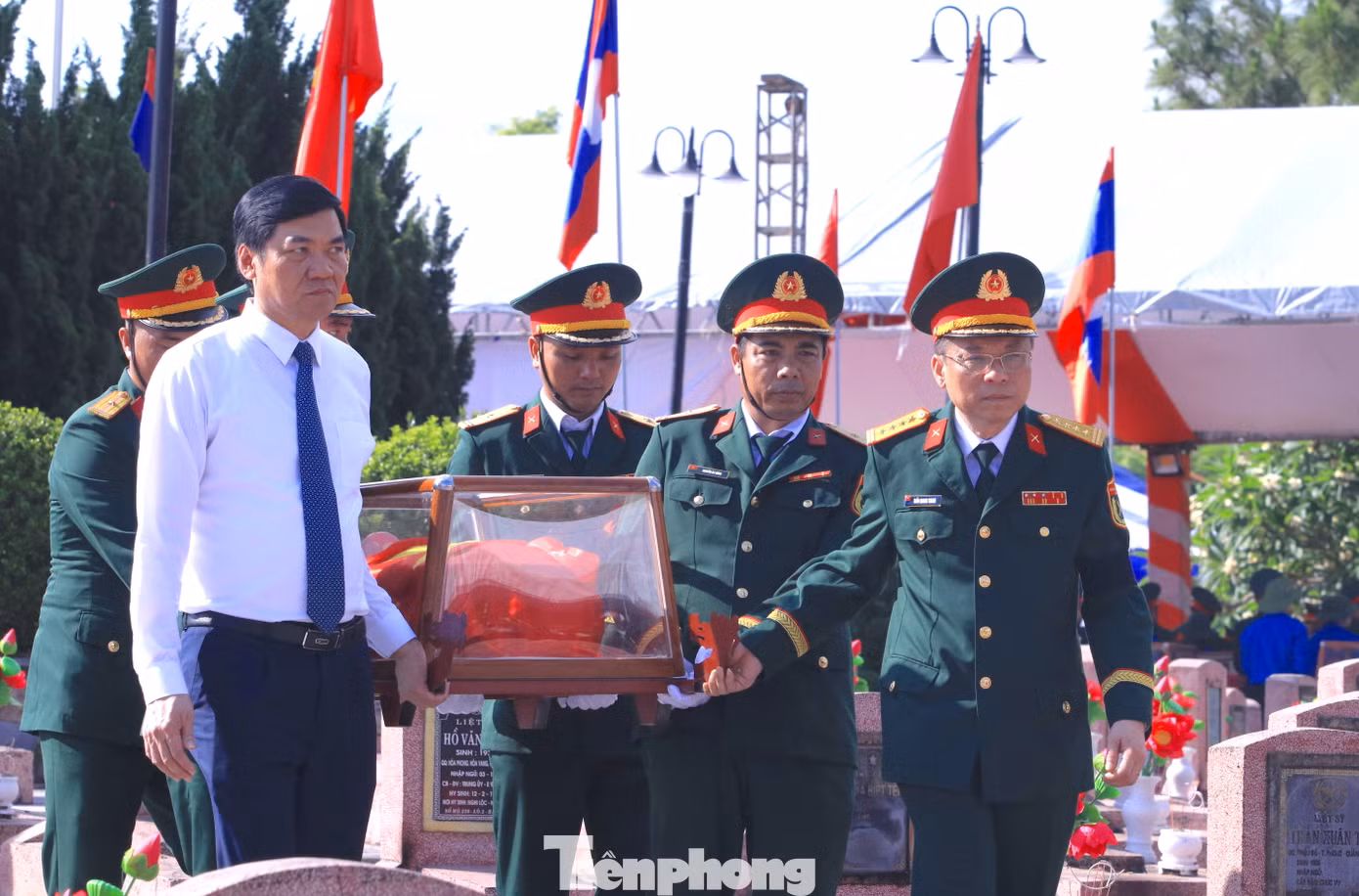 Các đại biểu di chuyển hài cốt liệt sĩ đến vị trí an táng trong nghĩa trang.