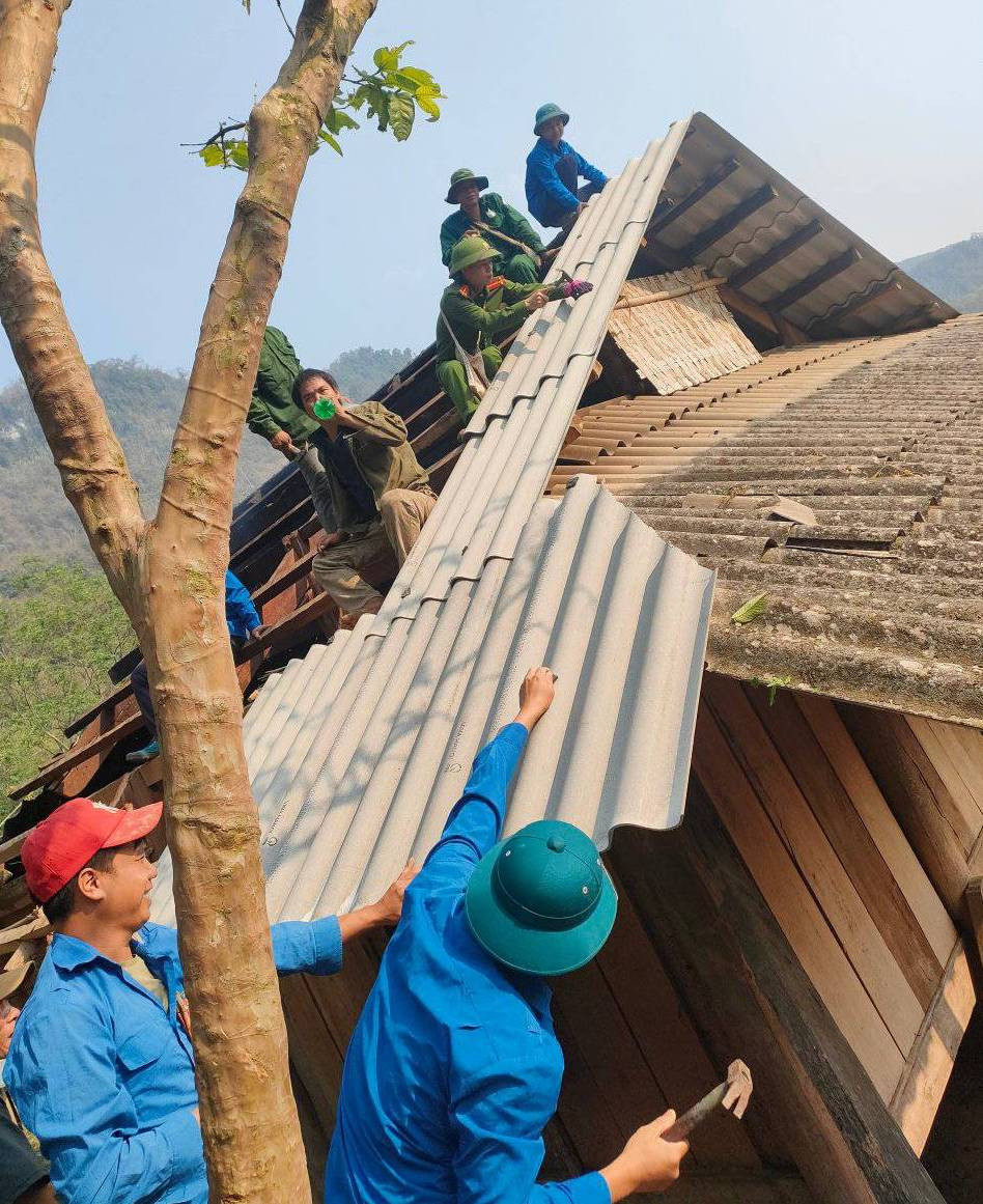 Các đoàn viên thanh niên nhiệt tình hỗ trợ người dân lợp lại mái ngói bất kể trời nắng nóng hay mưa.