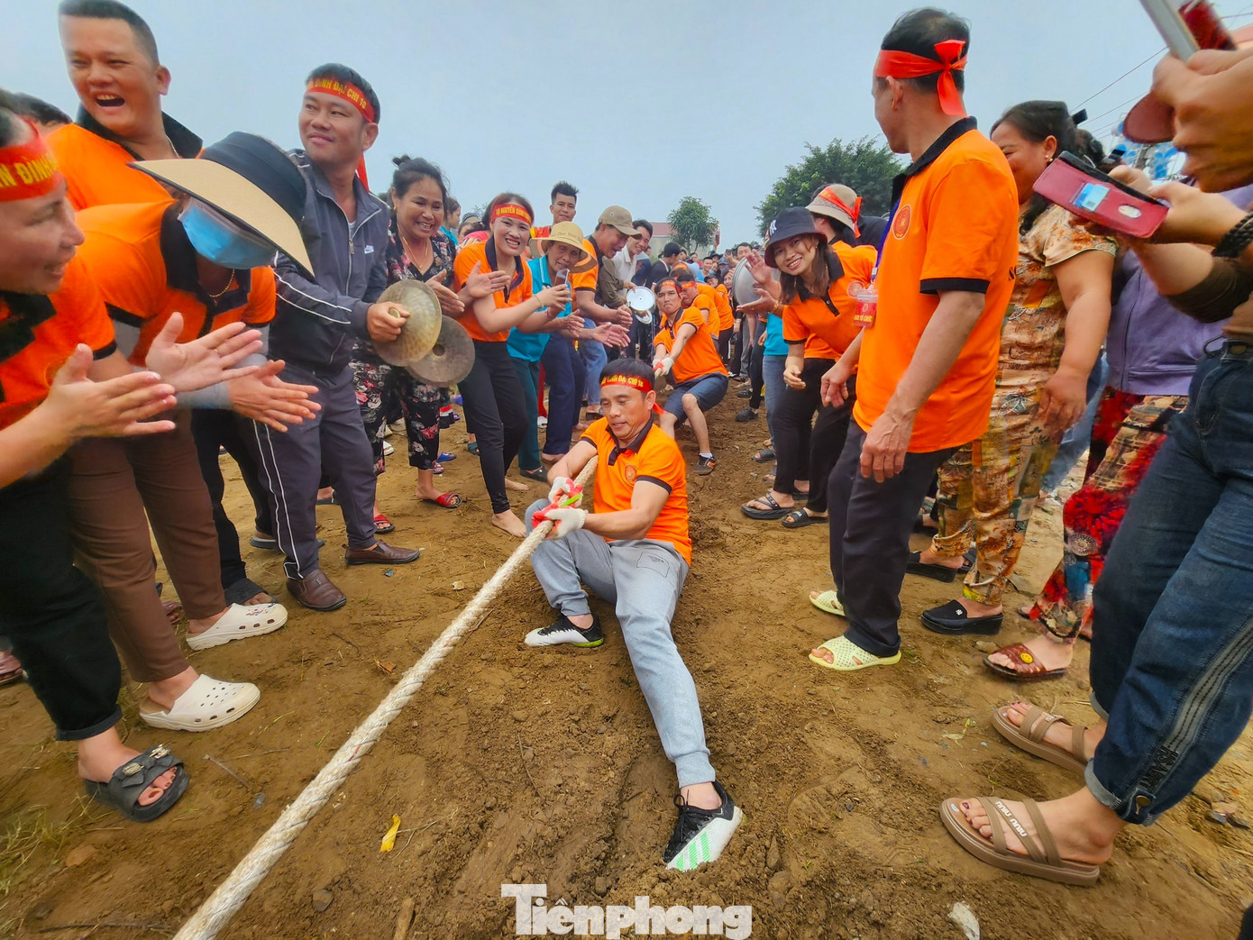 Nhiều vận động viên gần như ngồi bệt giữa nền đất để cố gắng kéo co.