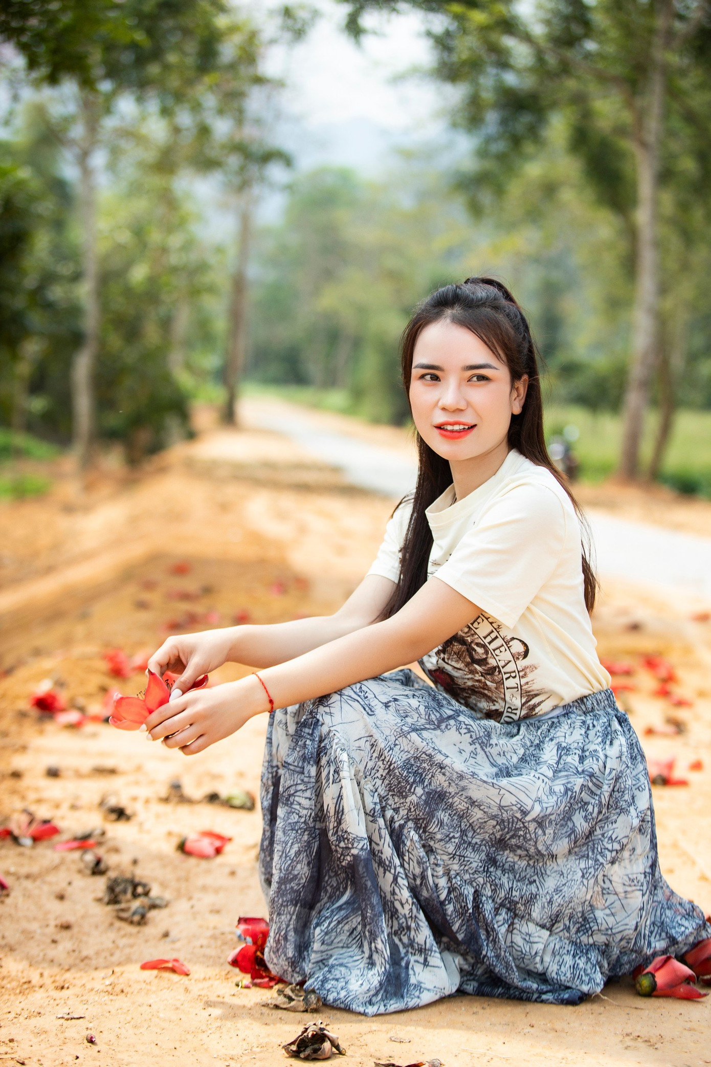 Những thiếu nữ xinh xắn tranh thủ chụp hình lưu niệm bên bông hoa gạo tháng 3. (Ảnh: Rạng Đông)