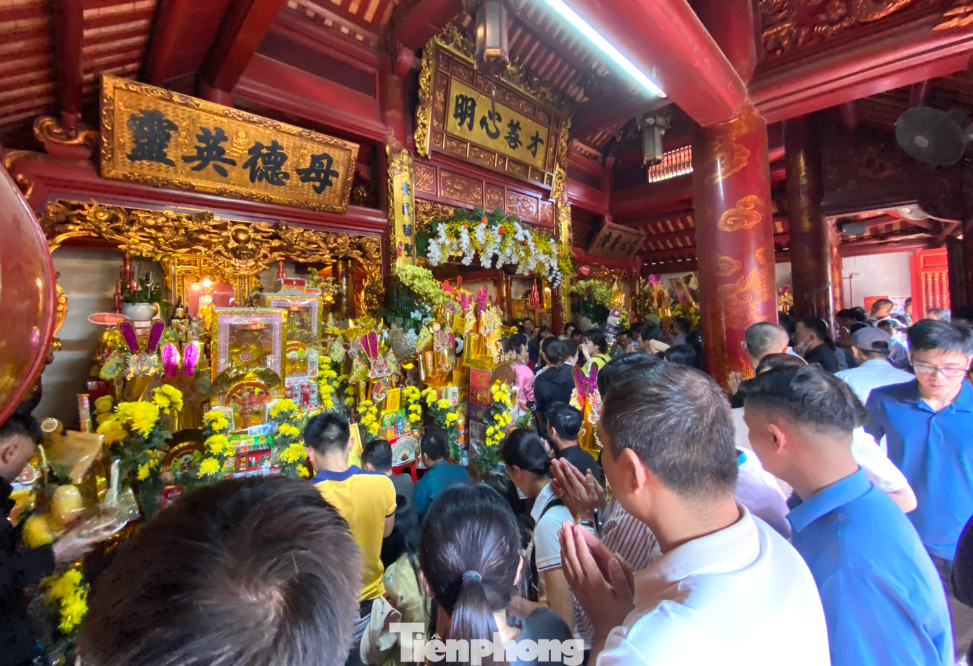 Bên trong khuôn viên đền chật kín người đứng, ngồi cúng bái.