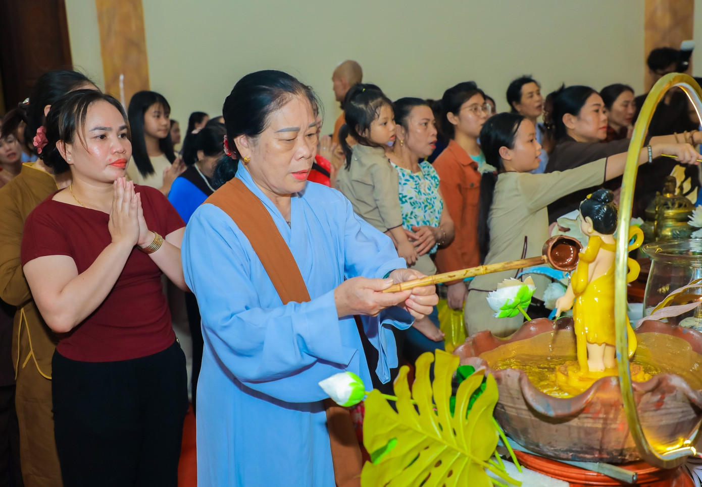 Các phật tử, người dân xếp hàng thực hiện nghi lễ tắm phật.