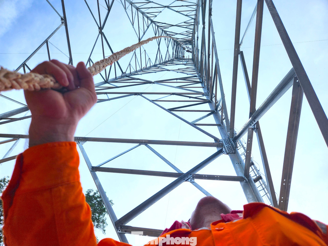 "Cột điện cao hơn 70m, đứng dưới đất nhìn lên không thấy đỉnh đâu. Mấy hôm nay thời tiết nắng quá, mình làm việc phía dưới đất còn đỡ, chứ anh em làm nhiệm vụ trên cao còn vất vả gấp bội lần", ông Quách Đình Dương (Tổ trưởng tổ xung kích Công ty điện lực Hòa Bình) đứng dưới chân cột điện vừa giữ chiếc dây néo vật liệu để các công nhân phía trên thuận tiện lắp đặt cấu kiện vừa chia sẻ.