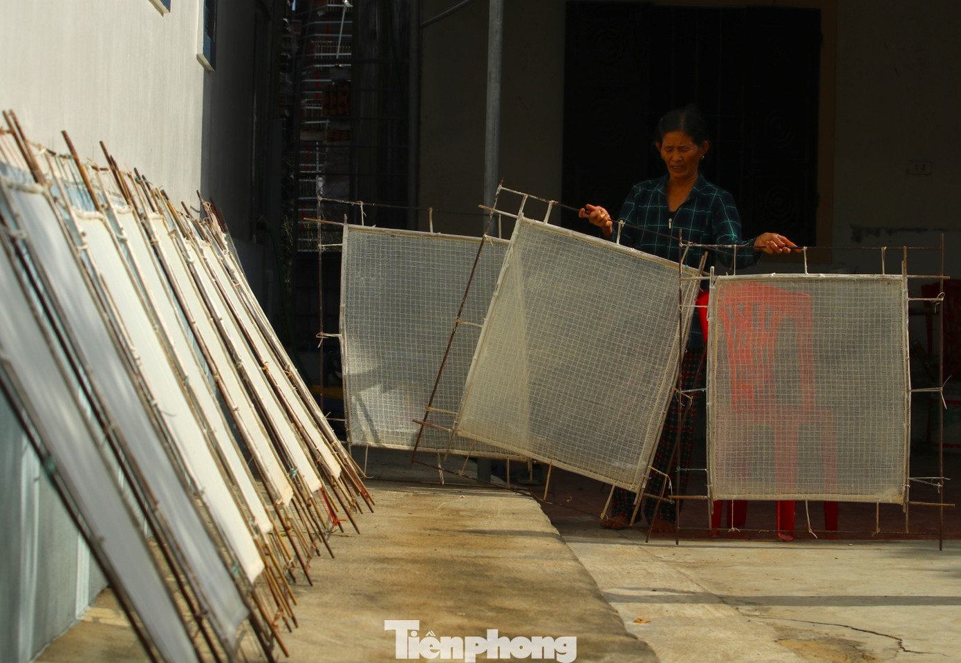 Sau khi những khuôn giấy được tráng một lớp nước mỏng tanh, bà Hải mang ra nắng phơi khô.