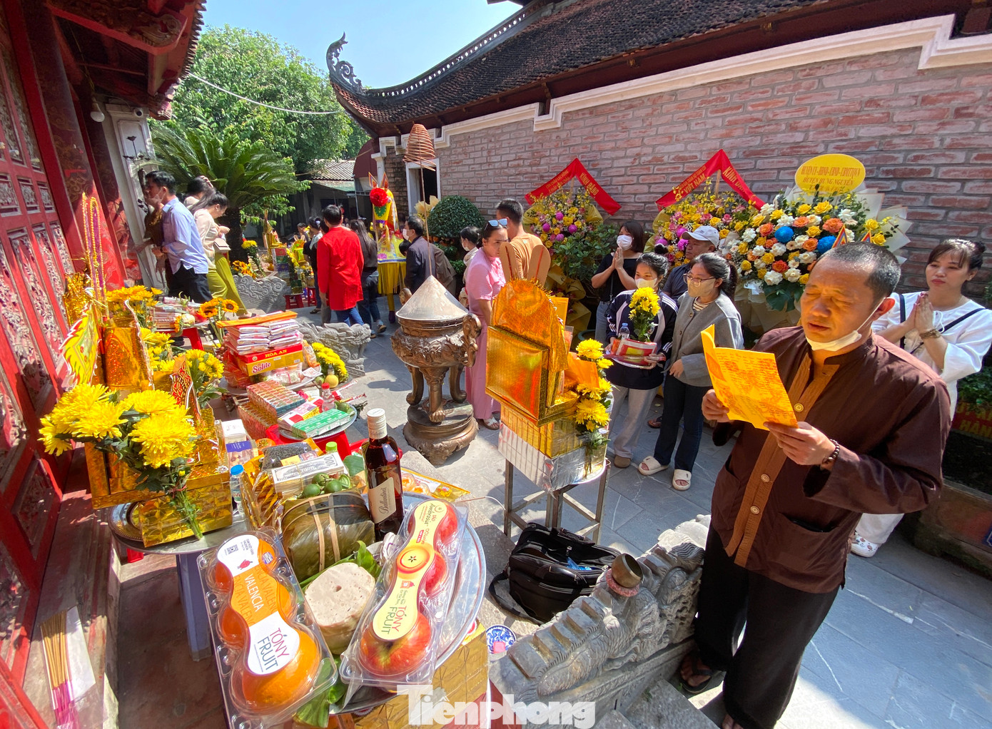 Bên trong chật kín chỗ, nhiều du khách phải đặt mâm lễ ở phía ngoài đền rồi làm lễ.