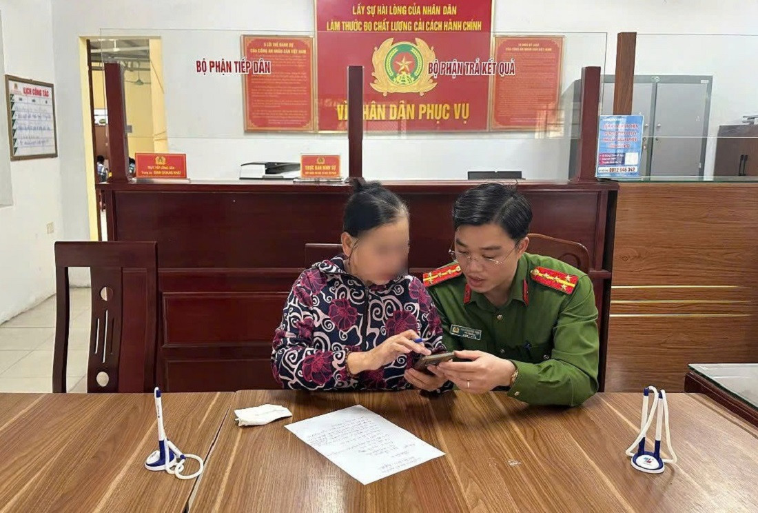 Đại úy Nguyễn Công Thận - Phó Trưởng Công an phường Quỳnh Thiện giải thích cho bà Tr. về việc bà bị lừa đảo.