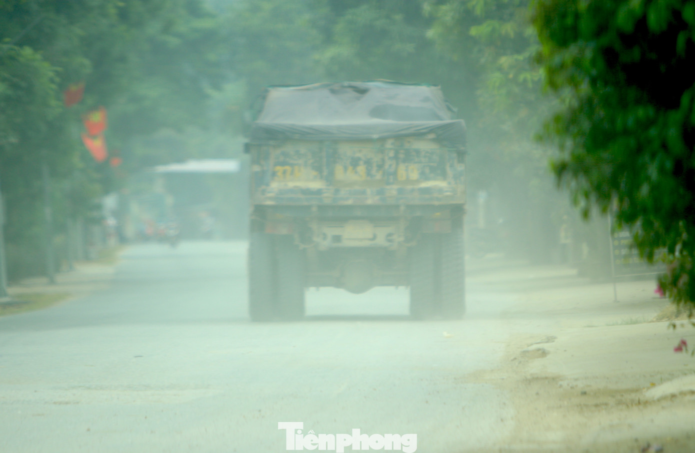 Bụi bay mù mịt mỗi khi có xe ben, xe tải chạy qua khiến người dân hai bên đường bức xúc.