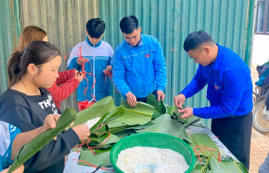 Các đoàn viên, cán bộ công an và các em học sinh cùng nhau gói những chiếc bánh cổ truyền.