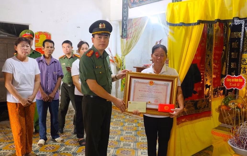 Đại tá Trần Hồng Quang - Phó Giám đốc công an tỉnh Nghệ An trao Huân chương Bảo vệ Tổ quốc hạng Ba đến thân nhân anh Hoàng Thế Thắng.