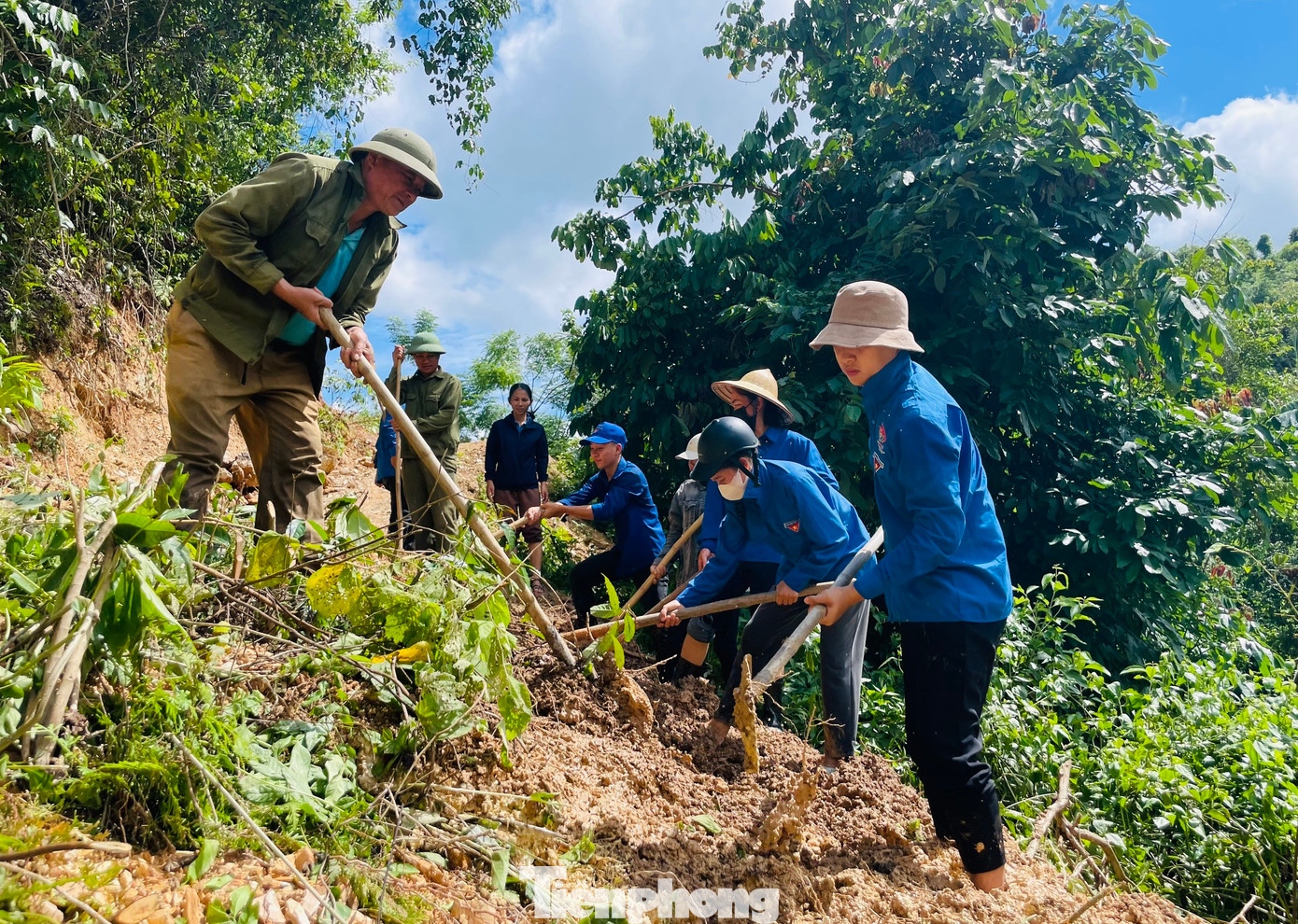 Các đoàn viên thanh niên cùng lực lượng dân quân san gạt những vị trí đường bị đất đá vùi lấp.