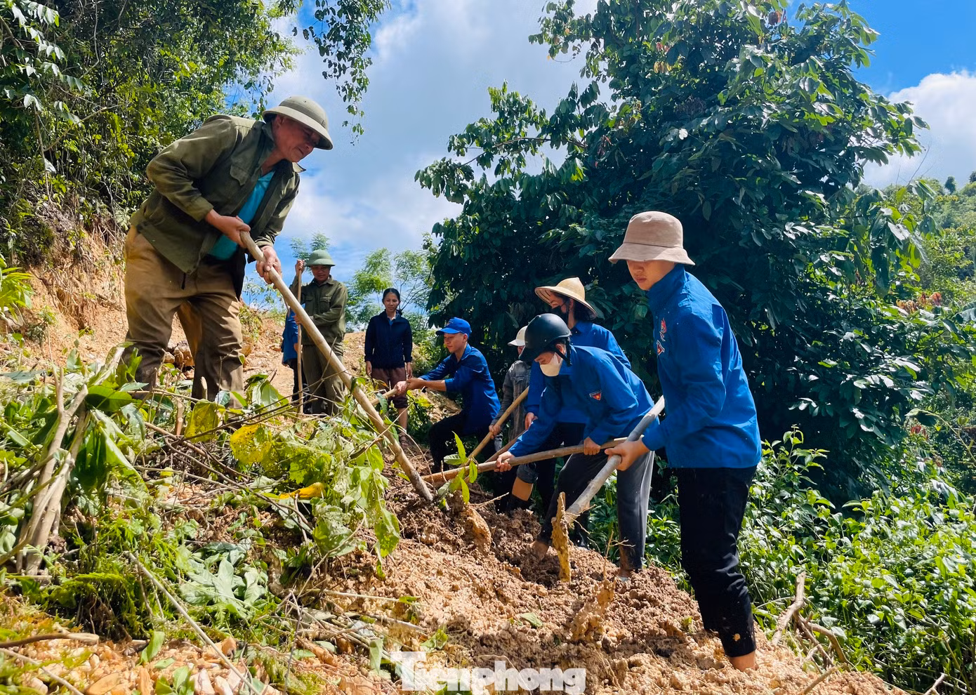 Các đoàn viên thanh niên cùng lực lượng dân quân san gạt những vị trí đường bị đất đá vùi lấp.
