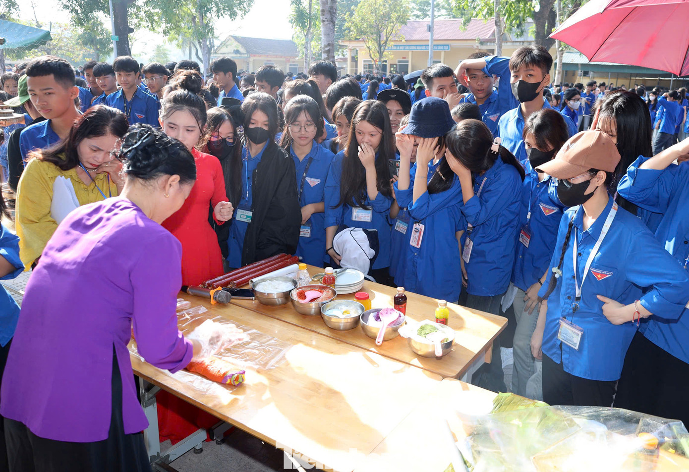 Các đoàn viên thanh niên chăm chú theo dõi nghệ nhân làm bánh ngũ sắc.