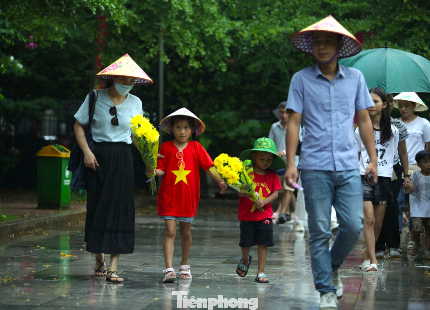 Nhiều em nhỏ mặc áo cờ đỏ sao vàng theo bố mẹ ôm bó hoa tươi thắm để dâng lên tưởng niệm Bác Hồ. Nhiều em nhỏ mặc áo cờ đỏ sao vàng theo bố mẹ ôm bó hoa tươi thắm để dâng lên tưởng niệm Bác Hồ.