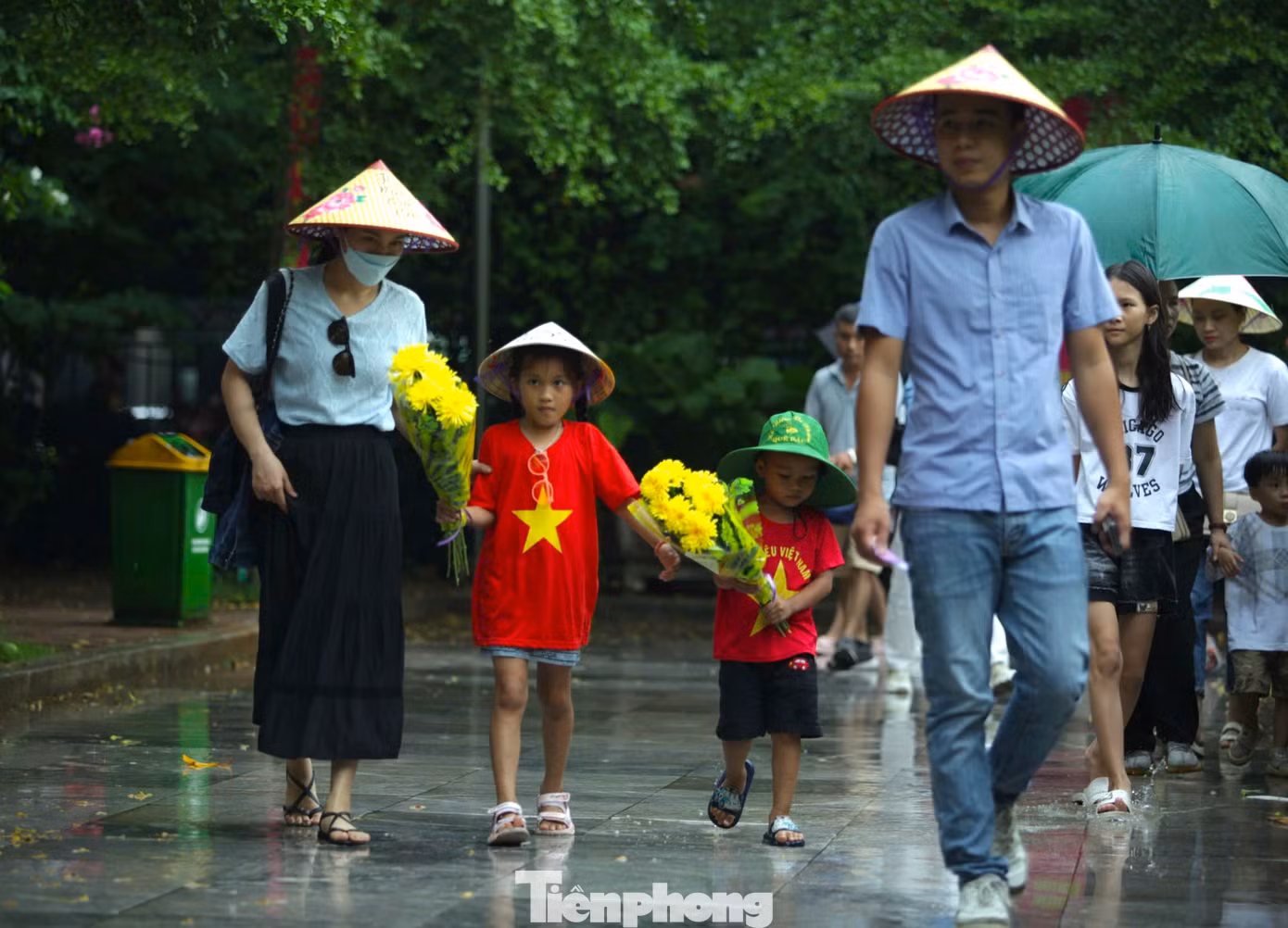Nhiều em nhỏ mặc áo cờ đỏ sao vàng theo bố mẹ ôm bó hoa tươi thắm để dâng lên tưởng niệm Bác Hồ. Nhiều em nhỏ mặc áo cờ đỏ sao vàng theo bố mẹ ôm bó hoa tươi thắm để dâng lên tưởng niệm Bác Hồ.