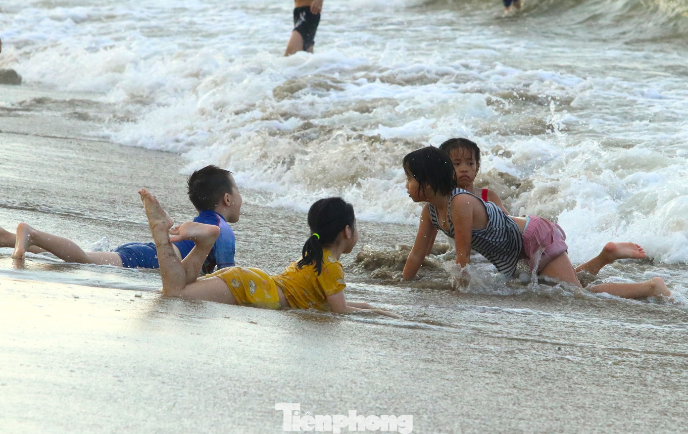Trong khi đó, nhiều em khác lại nằm ở mép nước chờ sóng biển đánh lên tạo cảm giác thích thú.
