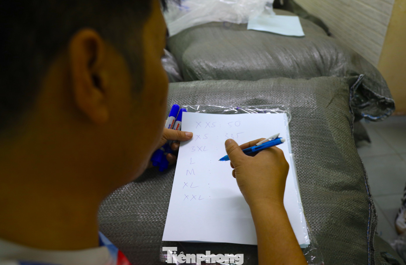 Tình nguyện viên cẩn thận ghi chép đầy đủ số lượng, phân loại trang phục cho vận động viên.