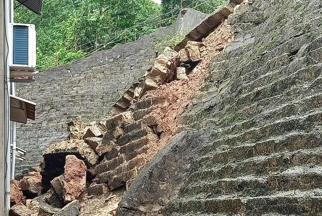 Bức tường rào kè chắn sát chân núi bị sạt lở xuống.