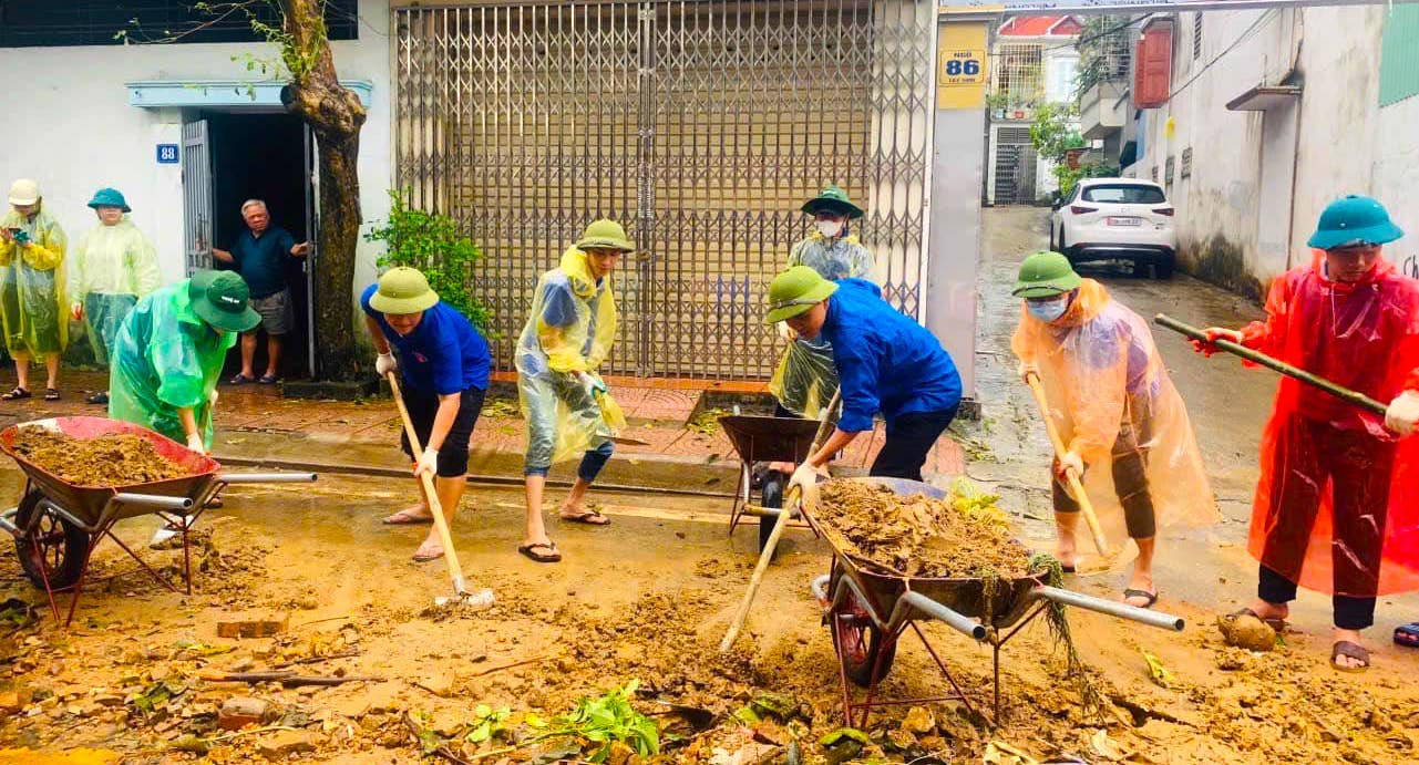 Các đoàn viên thanh niên đã sử dụng xe đẩy, cuốc, xẻng giải phóng lượng bùn đất đọng lại trên đường phố, nhà dân.