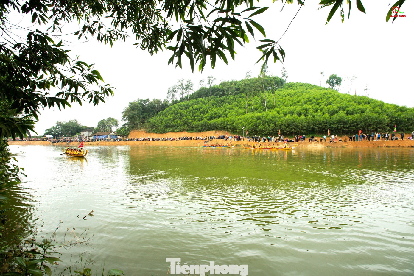 Khu vực tổ chức thi đua thuyền là đập Khe Trơi. Quãng đường đua dài 500m cả chiều đi lẫn chiều về. Hai bên bờ, hàng nghìn người đứng sẵn cầm cờ reo hò cổ vũ cho các đội đua. (Ảnh: Rạng Đông).