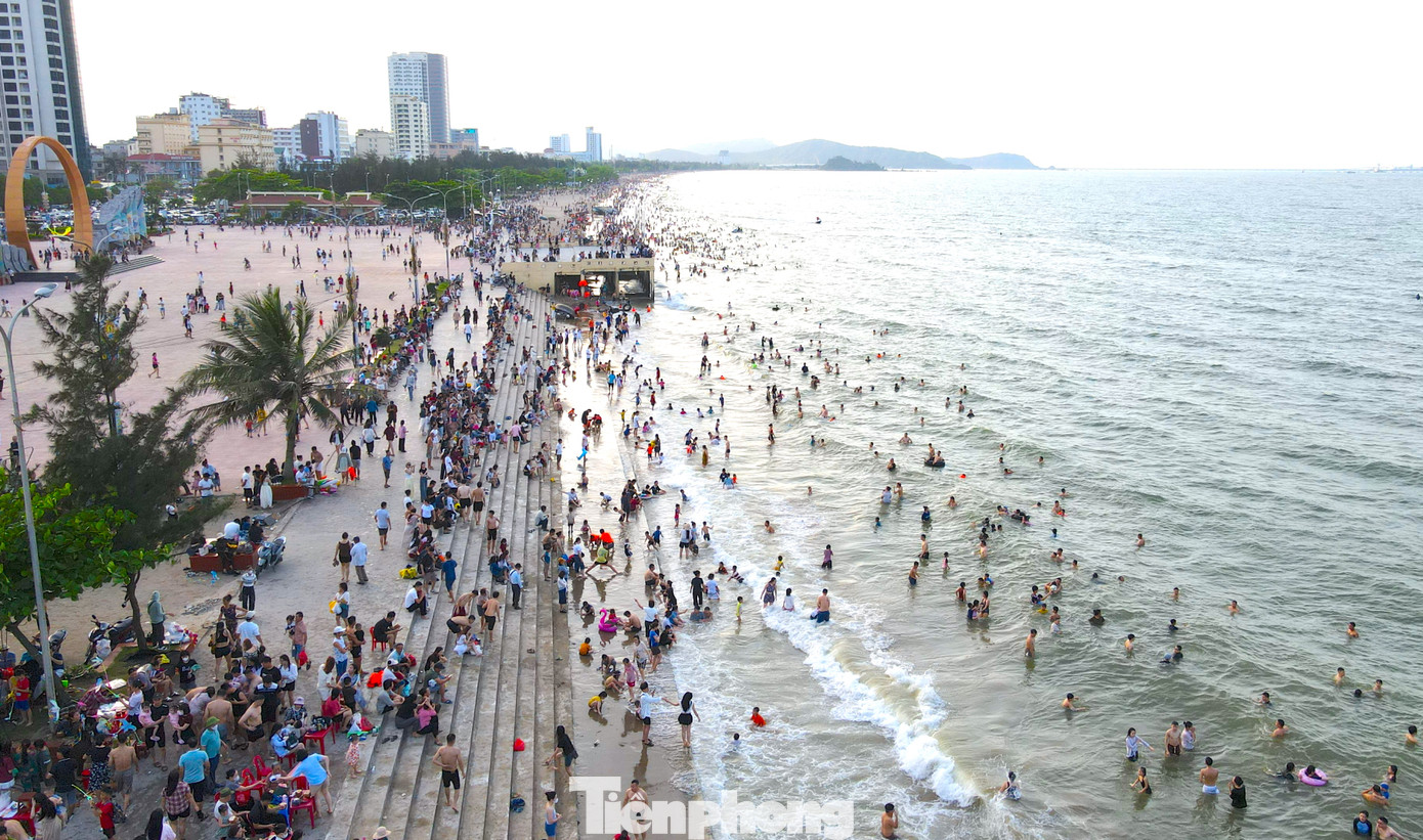 Dưới bờ biển, hàng vạn du khách đã xuống vui đùa với làn nước biển trong xanh, mát rượi. Dưới bờ biển, hàng vạn du khách đã xuống vui đùa với làn nước biển trong xanh, mát rượi.