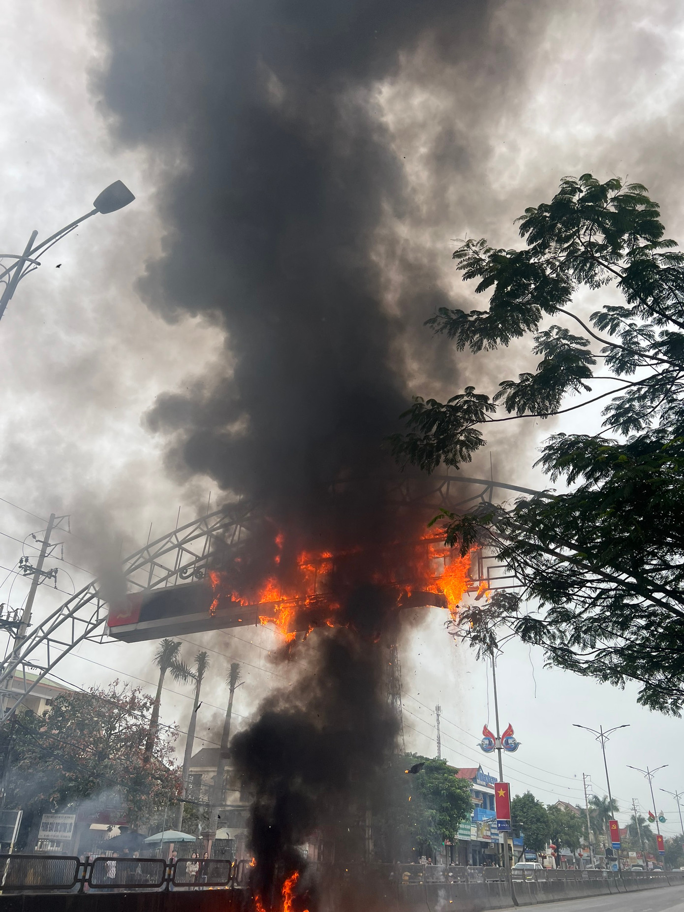 Đám cháy bùng phát lớn, tàn lửa rơi xuống mặt đường ở cả 2 chiều khiến các phương tiện giao thông không thể đi qua.