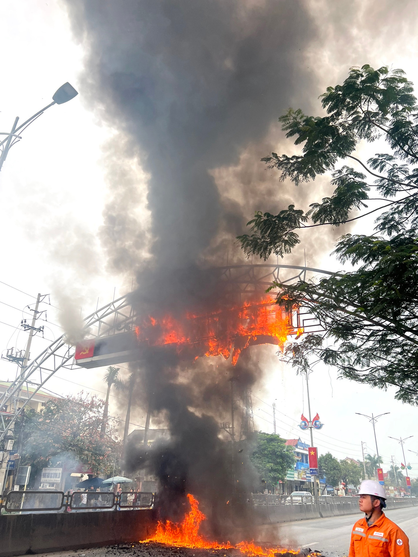 Đám cháy bùng phát lớn, tàn lửa rơi xuống mặt đường ở cả 2 chiều khiến các phương tiện giao thông không thể đi qua.