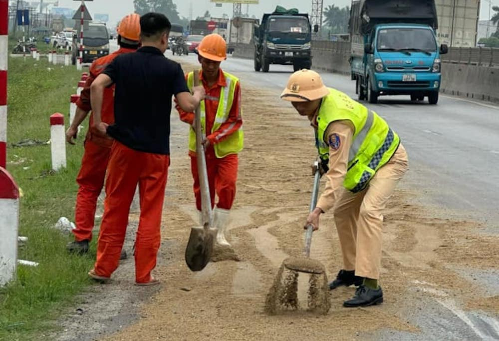 Cảnh sát giao thông cùng các công nhân và người dân rải cát lên khu vực dầu loang. Cảnh sát giao thông cùng các công nhân và người dân rải cát lên khu vực dầu loang.