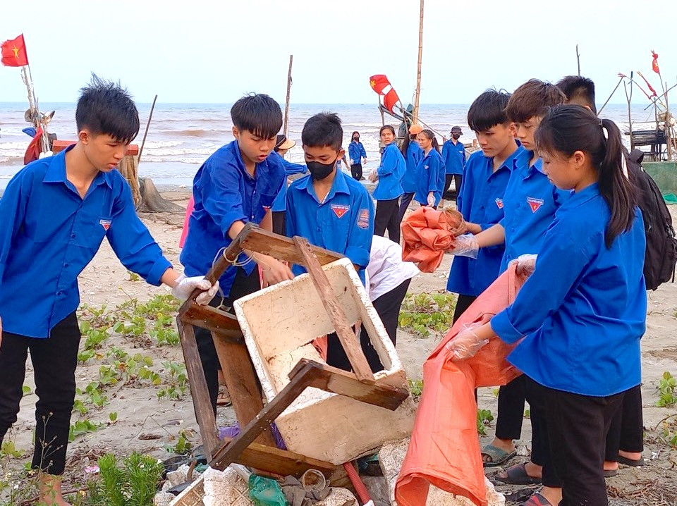 "Những loại rác này chủ yếu là bèo lục bình trôi dạt từ các con sông, kênh đổ ra biển. Chúng tôi đang huy động các đoàn thể tiếp tục thu dọn, làm sạch bãi biển trên địa bàn xã một cách sớm nhất", Chủ tịch xã Diễn Kim nói. Trong ảnh, các đoàn viên thanh niên xã Diễn Kim ra bờ biển của xã này dọn rác, làm sạch bãi biển.