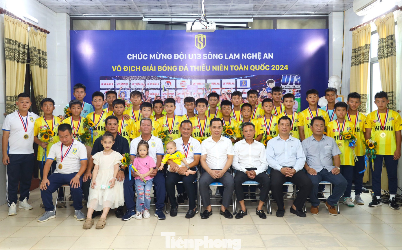 Các đại biểu chụp hình lưu niệm với ban huấn luyện và đội bóng U13 SLNA.