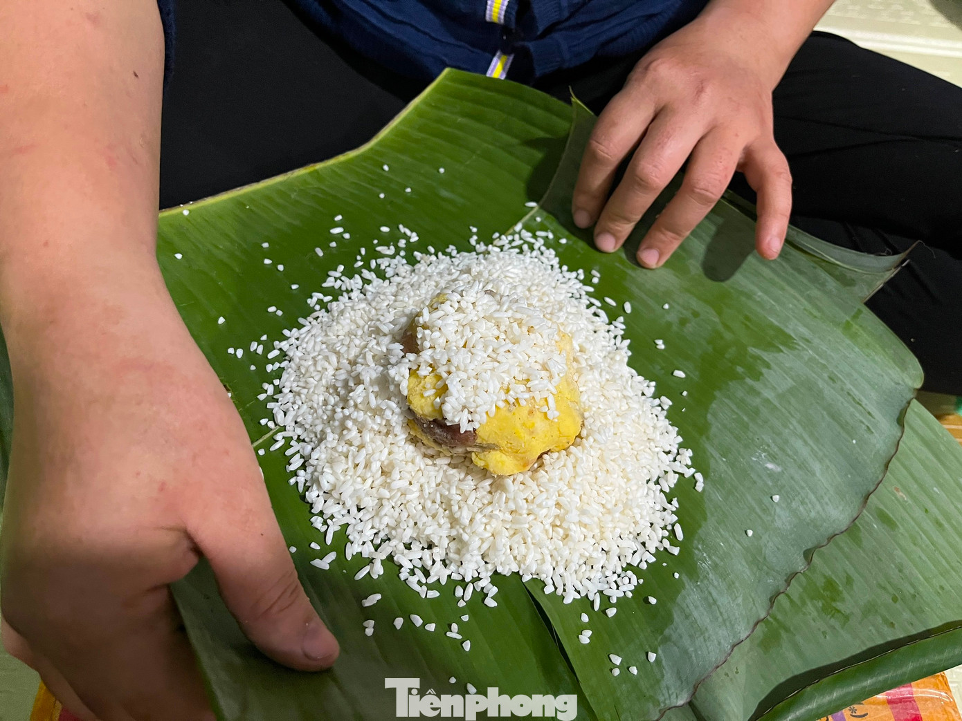 Khi gói, người thợ chỉ cần cho một lớp nếp phía dưới, đặt nhân bánh ở giữa rồi thêm một lớp nếp ở trên.
