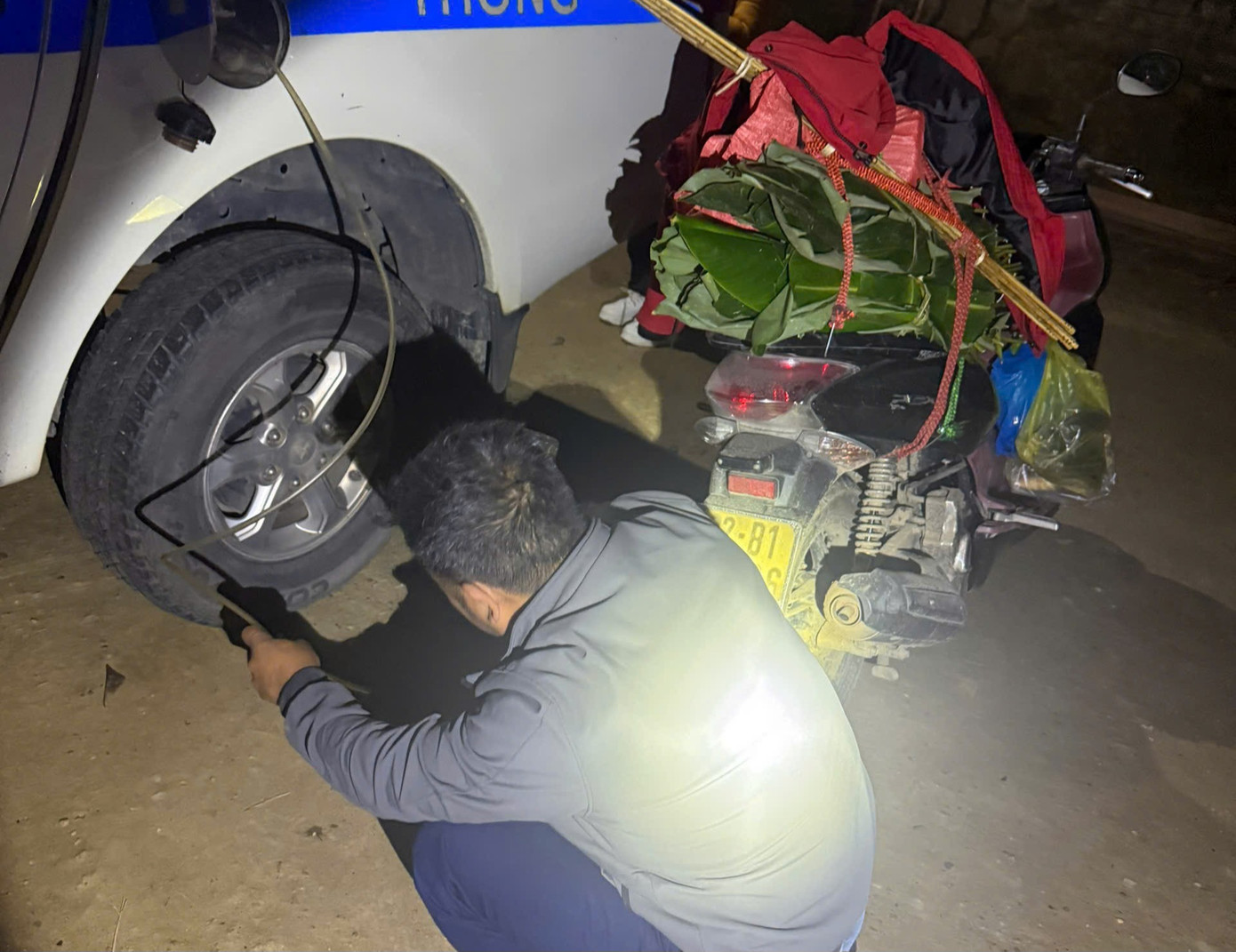 Tổ CSGT hút xăng từ xe ô tô tuần tra rồi nạp vào xe máy để chị Thúy tiếp tục hành trình dài an toàn.