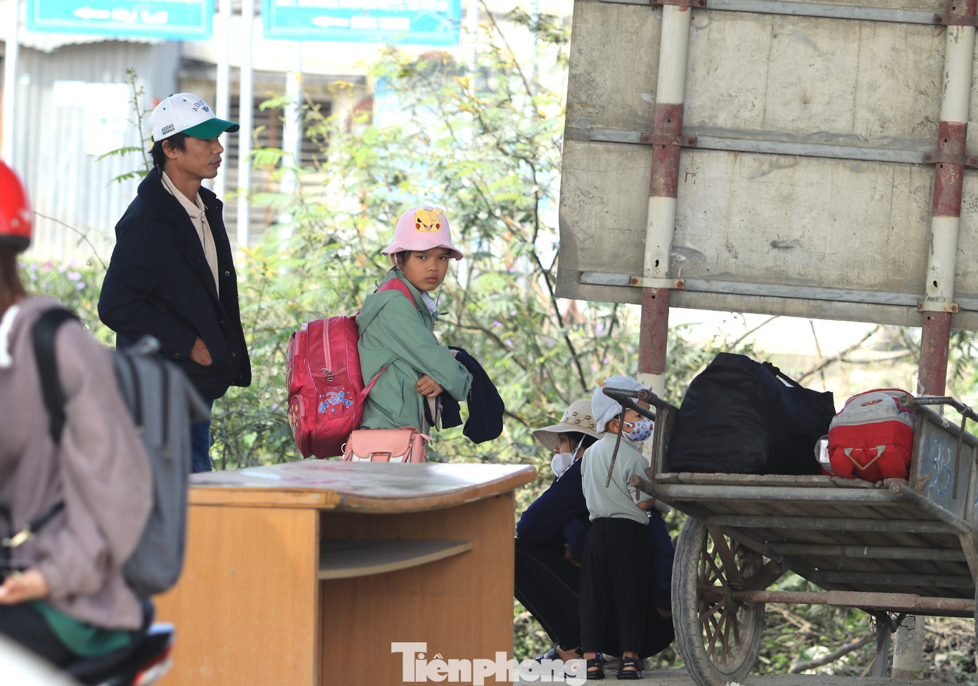 Nhiều gia đình chọn khu vực gầm cầu vượt để tránh nắng trong lúc chờ xe đến.