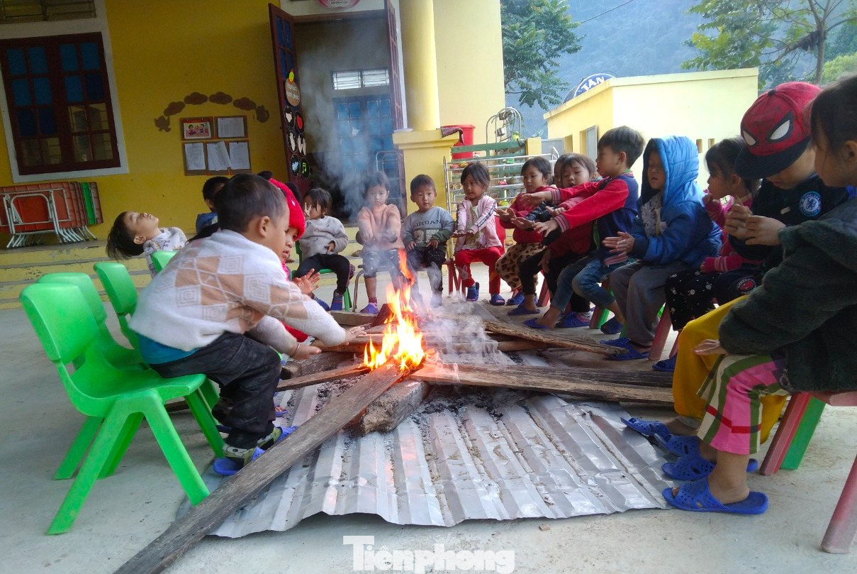 Các em học sinh được sưởi ấm tay, chân, người trước khi vào lớp học cho ấm.