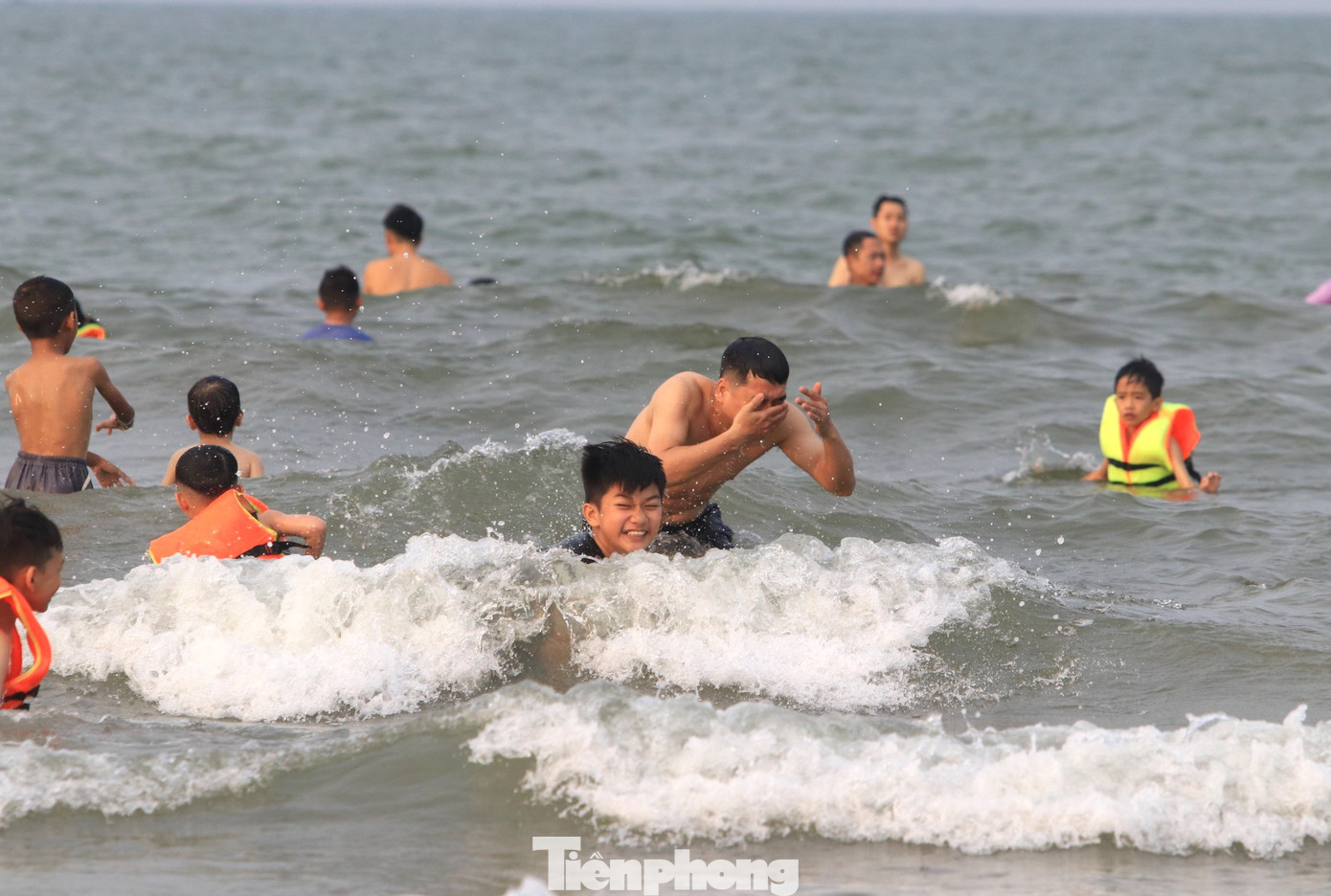 Dưới nước, du khách tắm mát và thích thú vui đùa cùng sóng biển. Dưới nước, du khách tắm mát và thích thú vui đùa cùng sóng biển.